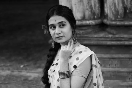 women wear simple oxidised earrings & bangles with matching polka dots saree for black and white bollywood style photo shot