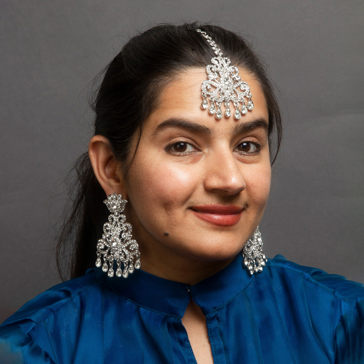 bindhani model wearing silver plated earrings with mang tikka for women