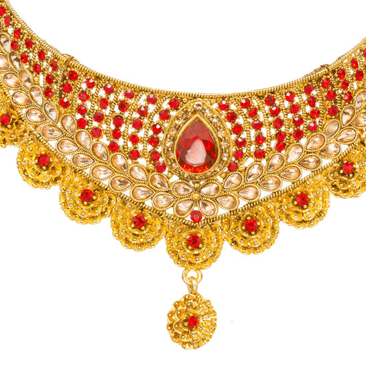 Front view of Bindhani gold-plated choker necklace featuring a pear-shaped red center stone, red and golden stone embellishments, intricate floral motifs, layered stone detailing, scalloped edges, and textured craftsmanship. Displayed on a white background.