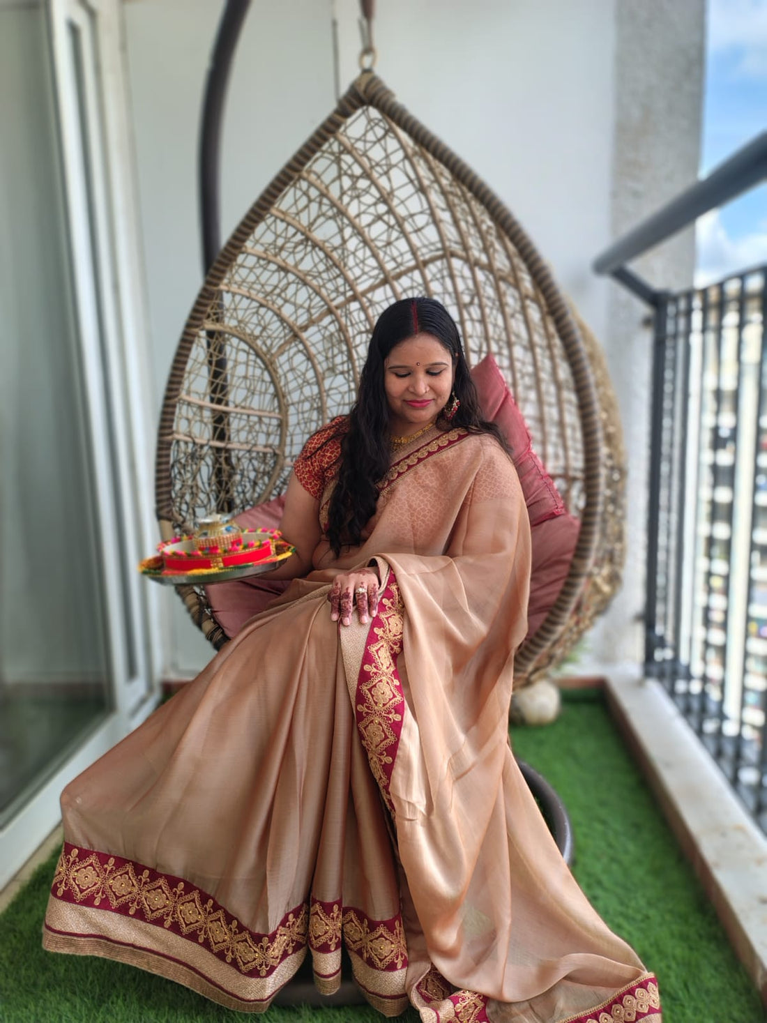 Lady sitting in red Bindhani earring with Karwachuth get up