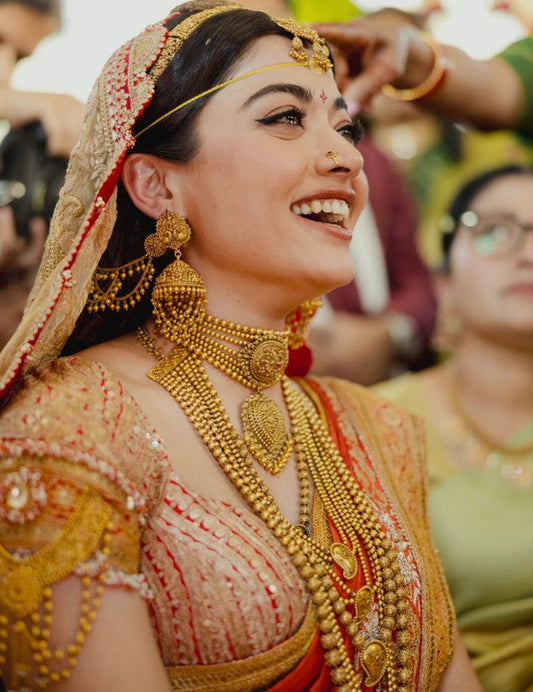 Rashmika M wearing Traditional gold jewelry on her wedding day.