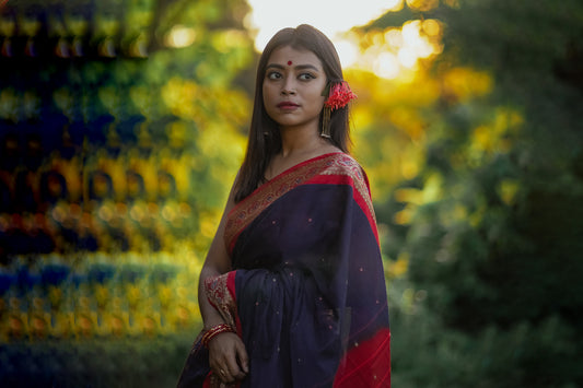 Beautiful women in blue gold border saree with latkan tassels earrings