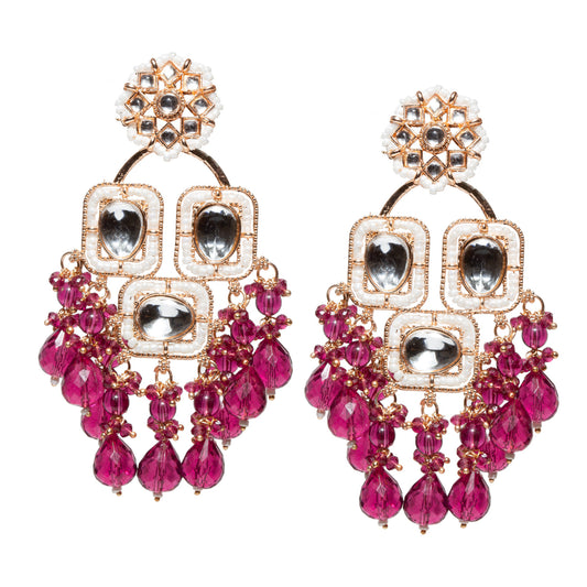 Statement earrings featuring a rose gold-tone floral stud top with pearl detailing, connected to a layered drop design with reflective rose gold-tone oval accents framed in gold. The lower section is embellished with cascading purple wine faceted beads and small purple wine bead clusters, creating a bold chandelier effect. Designed in a traditional festive style with vibrant contrast and intricate craftsmanship.