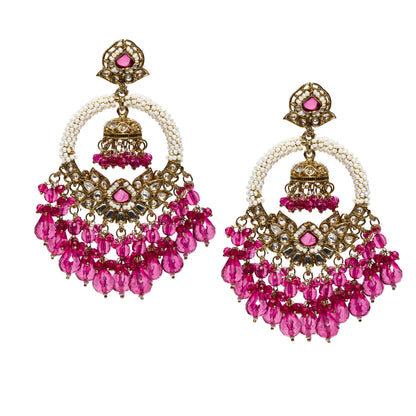 Bindhani antique gold-plated hoop jhumka earrings featuring a pearl-wrapped circular hoop with pink stone accents and intricate Kundan detailing. The center showcases an ornate floral-inspired design with a matching mini jhumka drop, while cascading faceted pink teardrop beads create a graceful fringe. Traditional statement earrings displayed as a pair on a white background.