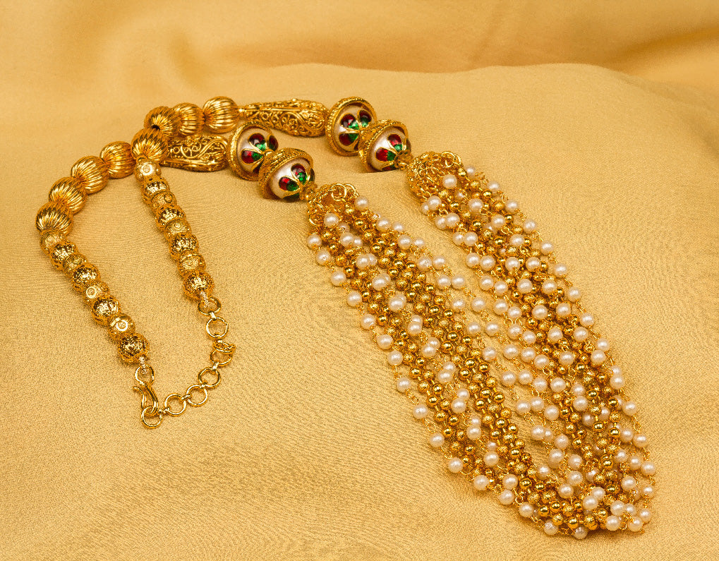 Bindhani Gold-plated multi-strand pearl necklace with meenakari beads on gold fabric background
