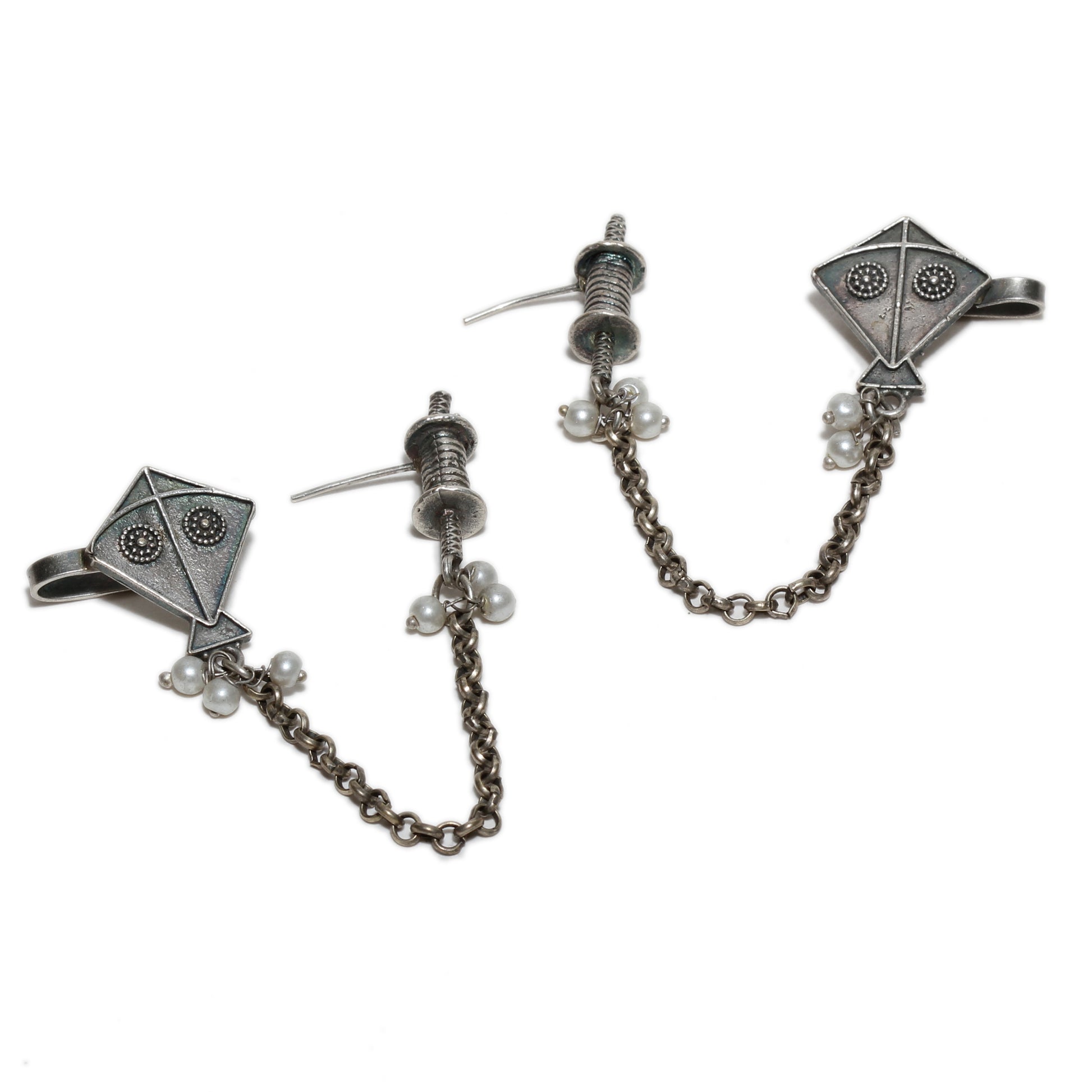 Pair of silver earrings with chain and pearl accents , kite motif on a white background