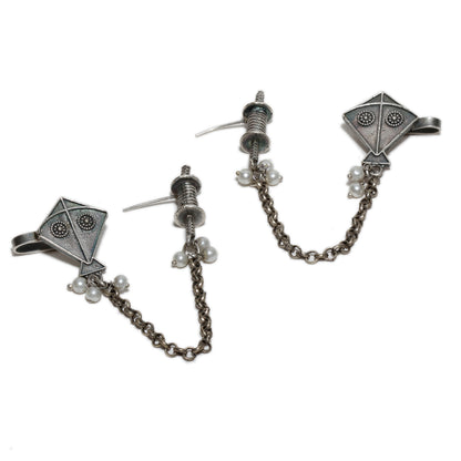 Pair of silver earrings with chain and pearl accents , kite motif on a white background