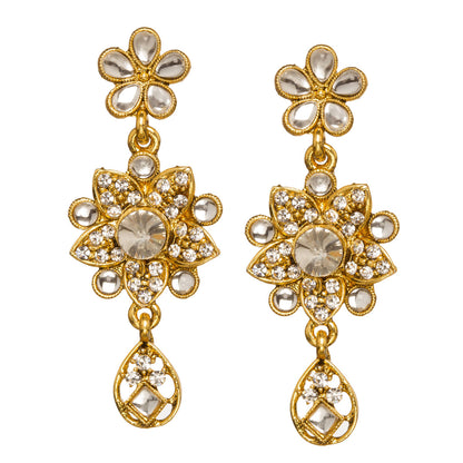Bindhani gold-plated floral drop earrings featuring a flower-shaped design with white stone accents, a central round stone, intricate gold detailing, and an elegant teardrop hanging charm. Traditional bridal earrings with sparkling stone embellishments, displayed on a white background.