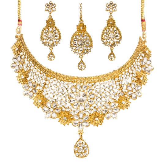 Bindhani gold-plated choker necklace set featuring white Kundan stones, floral motifs, intricate lattice detailing, crystal accents, and a teardrop pendant. The set includes matching floral drop earrings and a coordinating maang tikka with teardrop danglers, displayed on a white background.