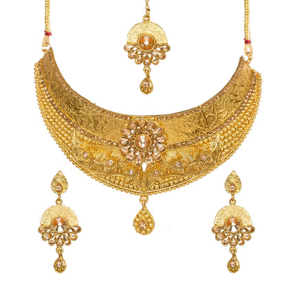 Bindhani gold-plated choker necklace set featuring engraved floral patterns, a central champagne-LCT stone flower motif, crystal accents, intricate textured detailing, and a teardrop pendant. The set includes matching drop earrings and a coordinating maang tikka with champagne-colored stones, displayed on a white background.