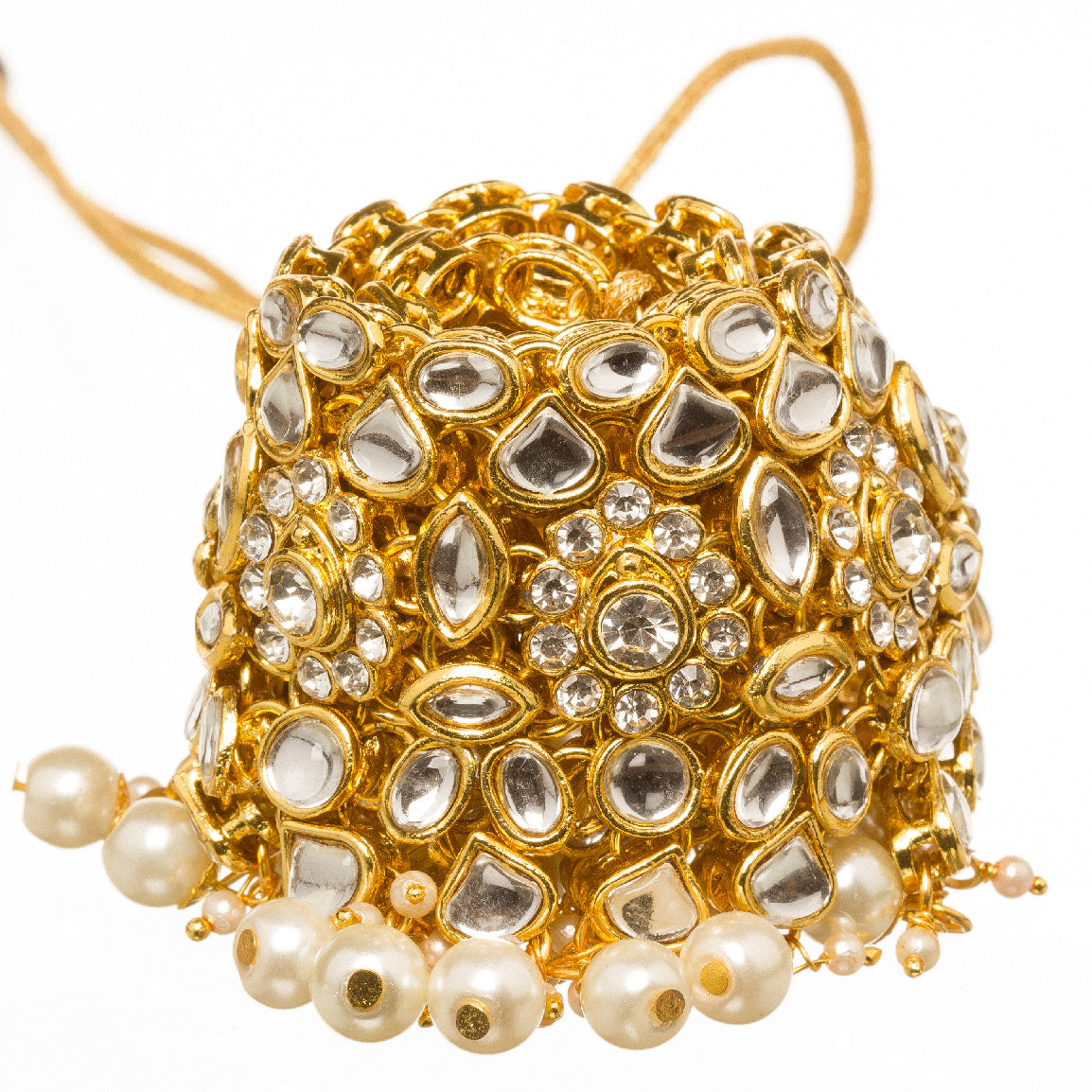 Close-up of gold-plated kundan-neklace choker with white pearl drops, white background