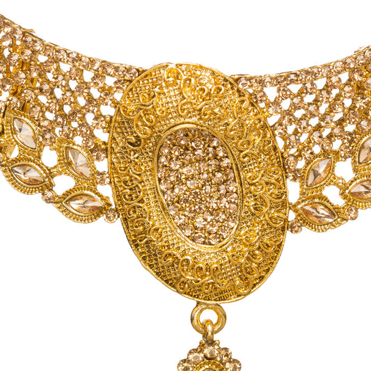 Bindhani gold-plated necklace set for women featuring an intricate traditional choker design with oval-shaped pendant, detailed filigree work, sparkling stone embellishments, matching earrings, and maang tikka with elegant gold craftsmanship on a white background.