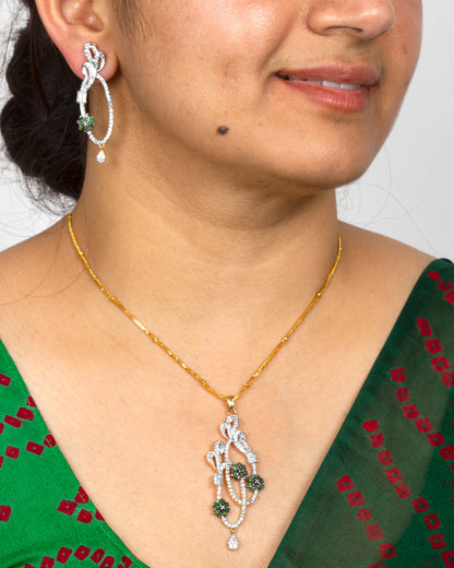 Bindhani gold-plated pendant with matching statement earrings, white stone studded abstract swirl design, green crystal flower accents, and drop detailing for ethnic party wear.