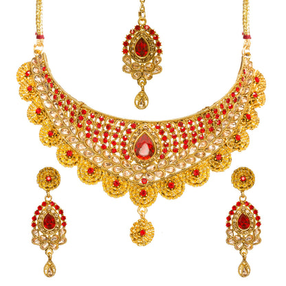Bindhani gold-plated choker necklace set featuring a pear-shaped red center stone, red and golden stone embellishments, intricate floral detailing, scalloped edges, and textured craftsmanship. The set includes matching drop earrings and a coordinating maang tikka with red and white stones, displayed on a white background.