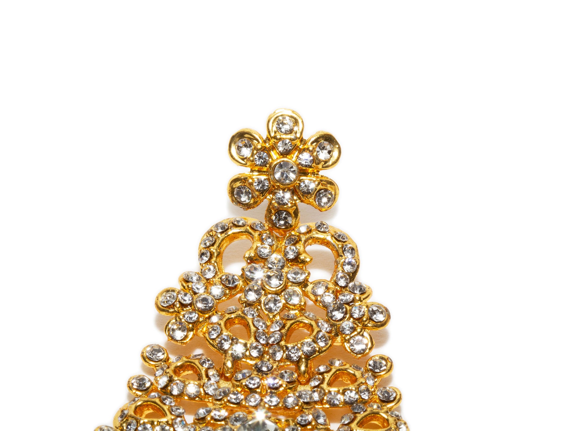 Bindhani close up picture of earrings stud showing stone work embedded in golden tone. 