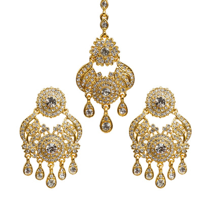 Bindhani gold plated maang tikka and earrings set featuring intricate floral and leaf-inspired designs with sparkling white stones. The set includes a matching long tikka with a central round stone design and statement earrings with circular floral tops, detailed openwork patterns, and multiple teardrop-shaped hanging stone drops. Traditional bridal jewelry set displayed on a white background.