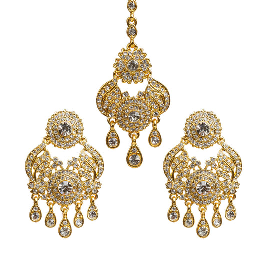 Bindhani gold plated maang tikka and earrings set featuring intricate floral and leaf-inspired designs with sparkling white stones. The set includes a matching long tikka with a central round stone design and statement earrings with circular floral tops, detailed openwork patterns, and multiple teardrop-shaped hanging stone drops. Traditional bridal jewelry set displayed on a white background.
