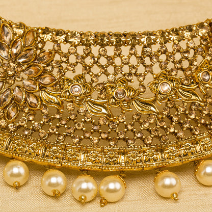 Bindhani gold-plated choker necklace set for women featuring intricate traditional design, elegant stone embellishments, golden beads detailed gold craftsmanship, a stylish bridal jewelry look on a grey background.