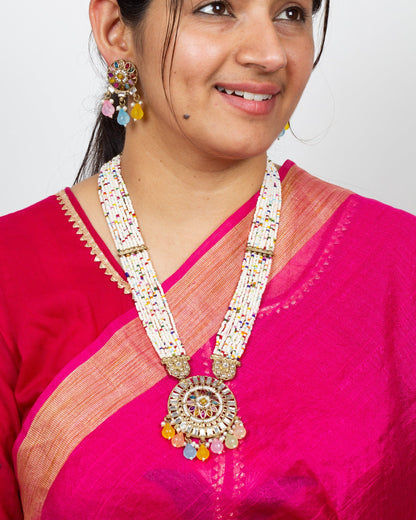 Woman wearing a Bindhani long Kundan stones Rani Haar pendant necklace set featuring intricate antique gold-plated craftsmanship with sparkling Kundan stones, traditional royal-inspired long necklace design, matching pendant, and coordinated earrings. Elegant ethnic jewelry set ideal for weddings, festive occasions, and bridal wear.