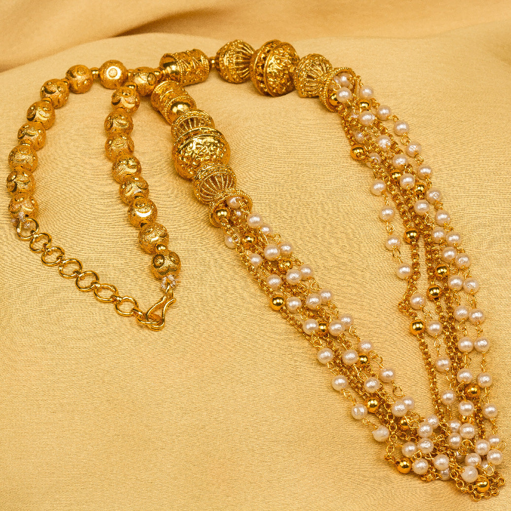 Close-up of gold-plated textured bead necklace with multiple pearl chain strands and lobster clasp, on gold fabric background