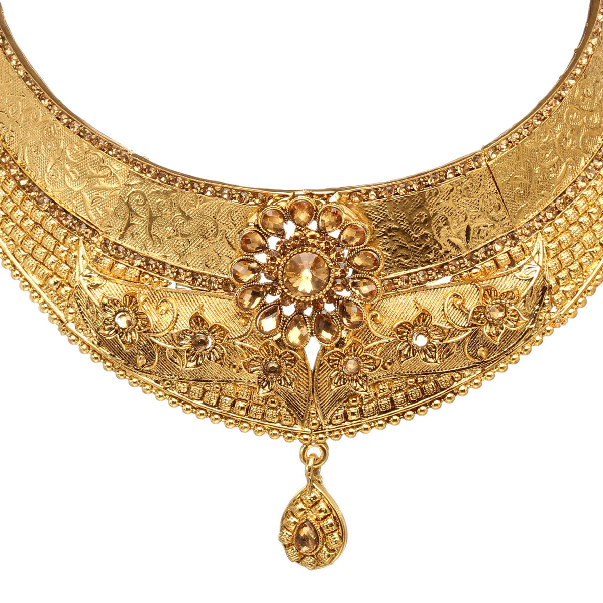 Front view of Bindhani gold-plated choker necklace featuring engraved floral patterns, intricate textured detailing, a central floral motif with a champagne-colored stone, crystal accents, and a teardrop-shaped pendant. Displayed on a white background.