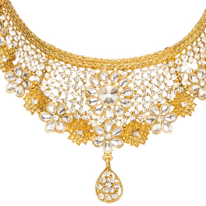 Front view of Bindhani gold-plated choker necklace featuring white Kundan stones, floral motifs, intricate open lattice detailing, crystal embellishments, and a teardrop-shaped crystal pendant. Displayed on a white background.