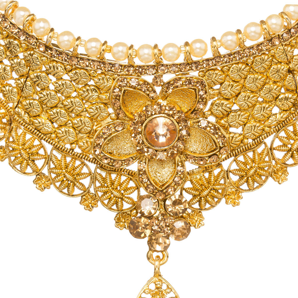 Front zoom view of Bindhani gold-plated choker necklace showcasing intricate filigree lattice craftsmanship, pearl border detailing, geometric patterns, a large floral centerpiece with a champagne-colored brown stone, and a teardrop-shaped crystal pendant. Displayed on a white background.