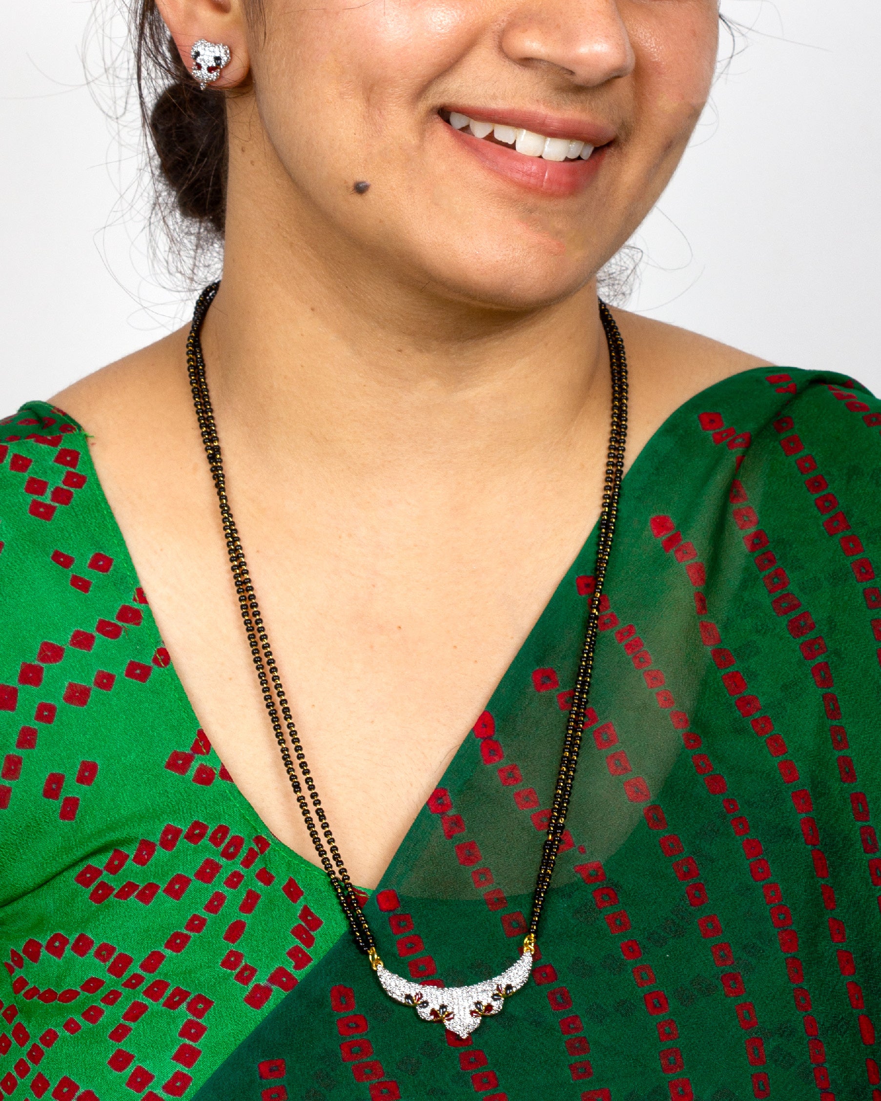 wearing Bindhani long mangalsutra karimani meenakari work, Pendant & stud  matching  and sparkling American Diamond stones – traditional Indian bridal jewelry for women.