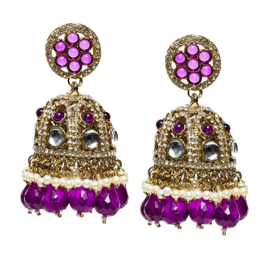 Bindhani antique mehandi gold-plated jhumka earrings featuring a round floral stud with emerald purple stones surrounded by shimmering crystals. The dome-shaped jhumka is embellished with white Kundan stones, purple stone accents, and sparkling crystals, finished with pearl tassels and faceted emerald purple bead drops. Traditional statement earrings displayed as a pair on a white background.