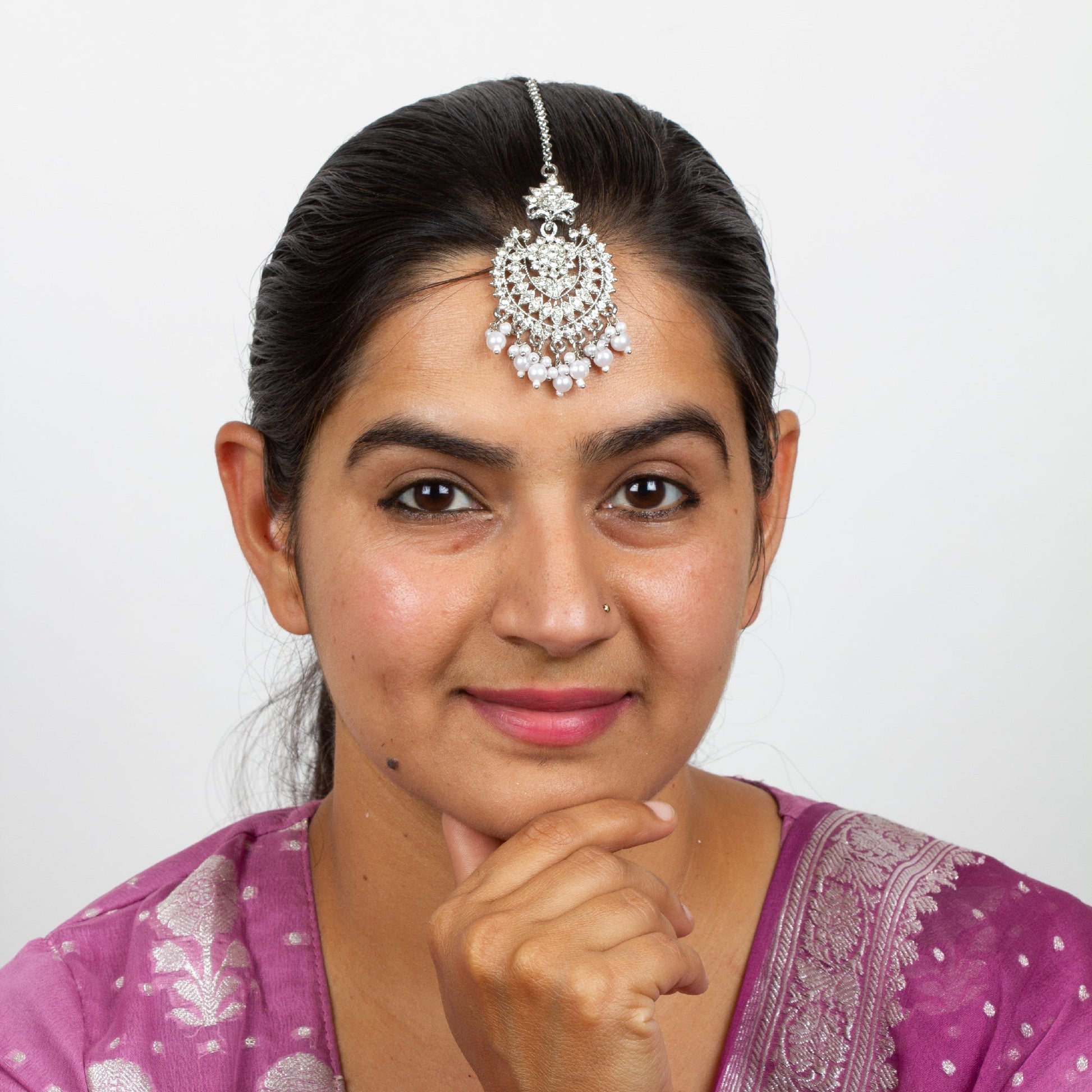 wearing bindhani silver
plated maang tikka positioned on the forehead.