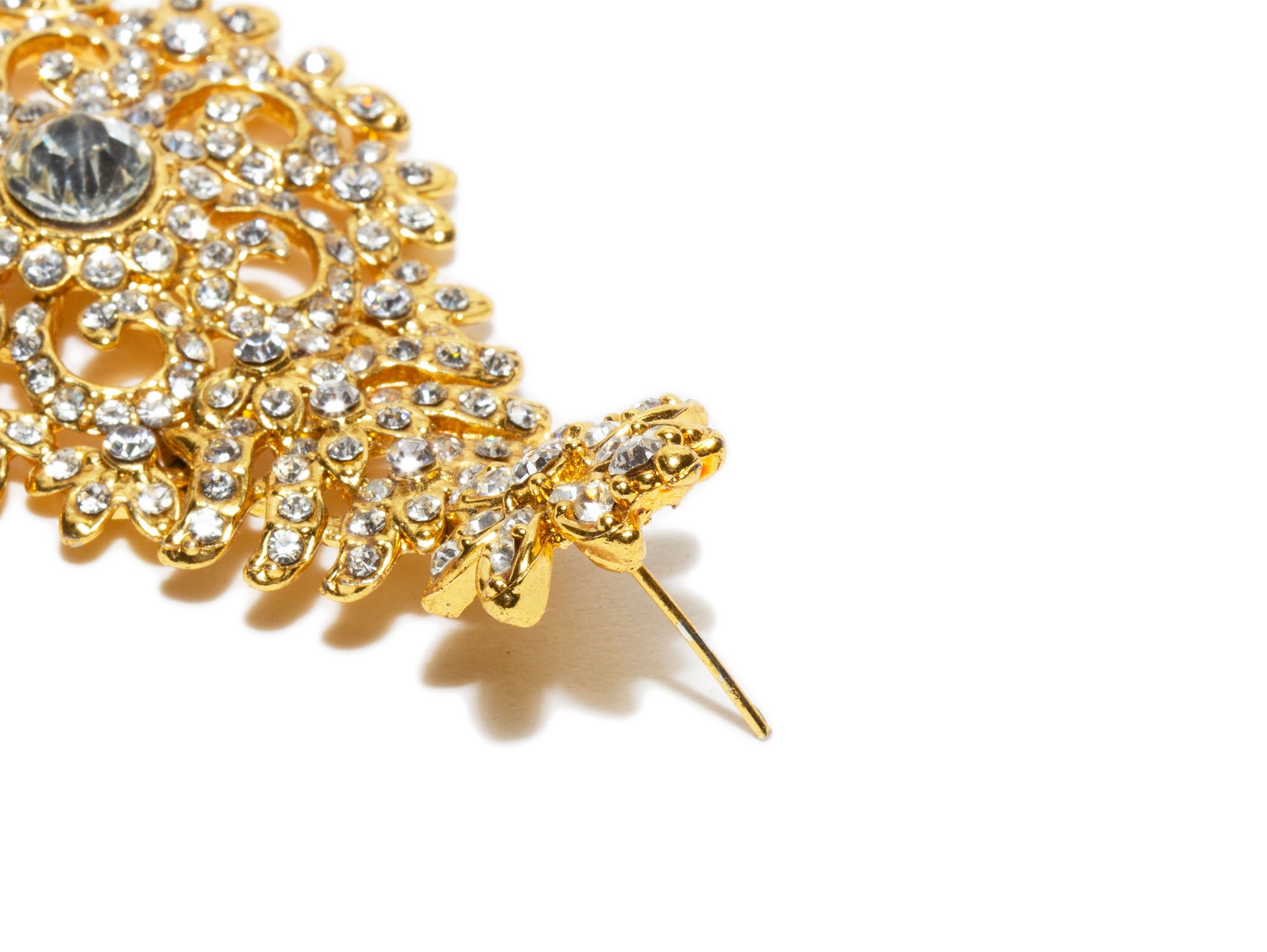 Bindhani close up picture of earrings stud showing stone work embedded in golden tone depicting post backlock in white background