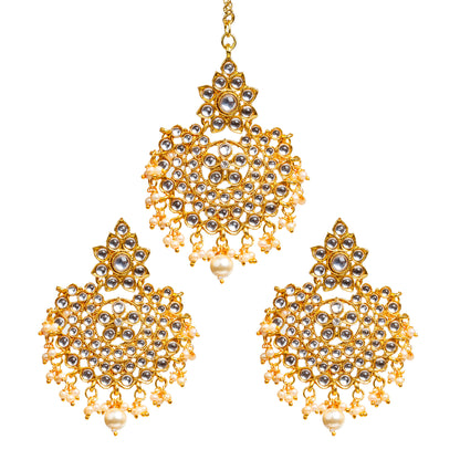 Bindhani gold-plated Kundan earrings and maang tikka set featuring clear Kundan stones with white pearl drop detailing. The earrings showcase a floral Kundan stone-studded top, an intricate circular openwork design with petal-shaped and round Kundan stones, and delicate white pearl hanging drops with a larger center pearl. The matching maang tikka features a coordinating floral top, circular Kundan design, and white pearl drop embellishments with a larger center pearl. Front view