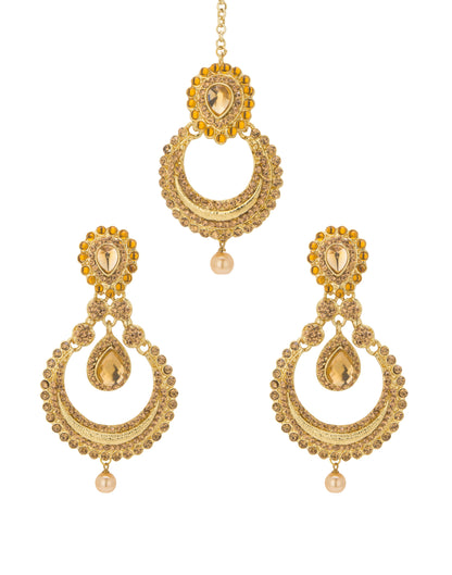 Bindhani gold-plated earrings and maang tikka set featuring antique gold-toned detailing with champagne-colored stones and pearl drop accents. The earrings showcase oval stone-studded tops, intricate circular openwork designs, teardrop-shaped center stones, and single pearl hanging drops at the bottom. The matching maang tikka features an oval stone-studded top, crescent-shaped openwork design, a teardrop centerpiece, and a pearl drop. Front view displayed on a white background.