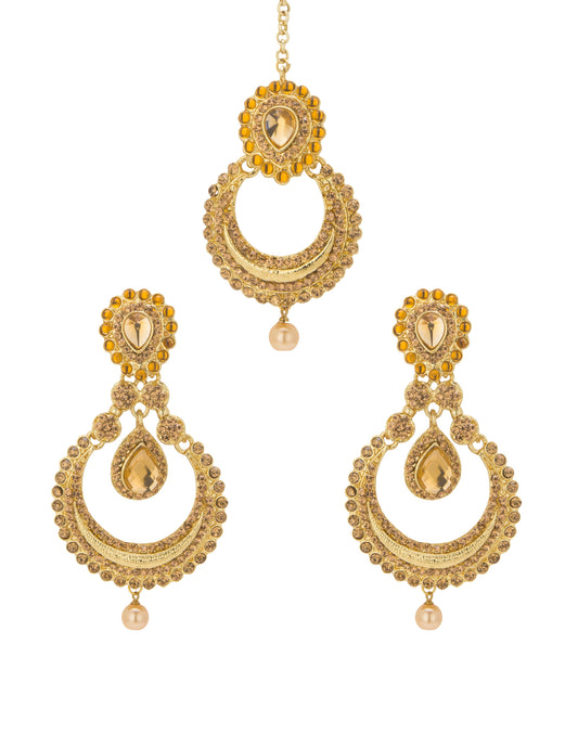 Bindhani gold-plated earrings and maang tikka set featuring antique gold-toned detailing with champagne-colored stones and pearl drop accents. The earrings showcase oval stone-studded tops, intricate circular openwork designs, teardrop-shaped center stones, and single pearl hanging drops at the bottom. The matching maang tikka features an oval stone-studded top, crescent-shaped openwork design, a teardrop centerpiece, and a pearl drop. Front view displayed on a white background.