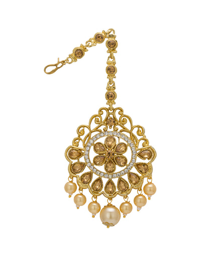 Bindhani gold-plated maang tikka featuring gold-toned detailing with clear stones and white pearl drop accents. The tikka showcases a circular floral design with intricate openwork filigree, teardrop-shaped stone detailing, and multiple pearl hanging drops with a larger center pearl. Front view displayed on a white background.