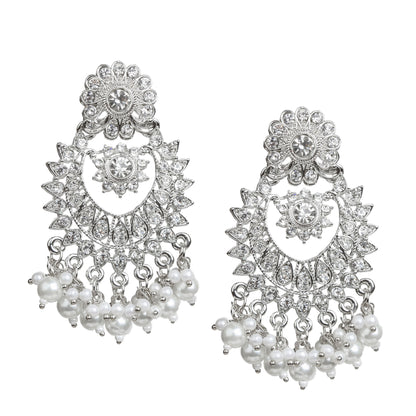 Bindhani silver-plated chandbali earrings featuring intricate floral and crescent-shaped designs adorned with clear stones. The earrings have a floral stud top, an ornate floral centerpiece, detailed openwork, and white pearl bead tassels along the bottom edge. Front view displayed on a white background.