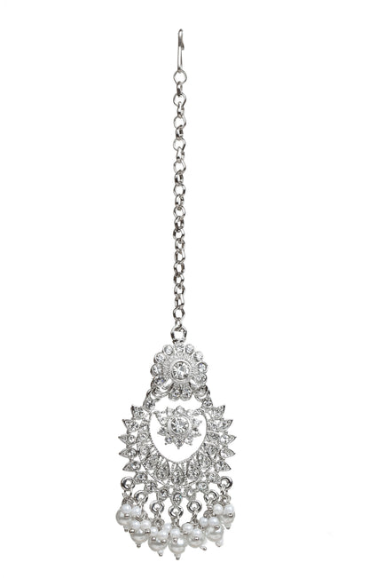 Bindhani silver-plated maang tikka featuring an intricate floral top with a crescent-shaped design adorned with clear stones. The tikka is finished with white pearl bead tassels and attached to a delicate silver-toned chain. Front view displayed on a white background