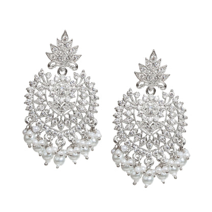 Bindhani silver-plated statement earrings featuring a leaf-shaped stud top with an intricate openwork floral and geometric design embellished with clear stones. The earrings are accented with a central round stone and finished with dangling white pearl bead clusters. Front view displayed on a white