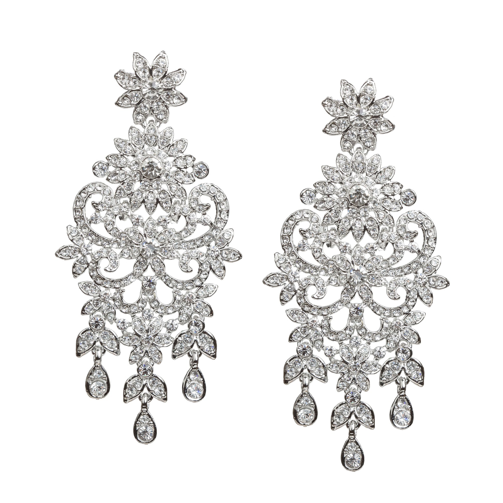 Bindhani silver-toned statement earrings featuring clear stones with sparkling crystal accents. Each earring showcases a floral top, intricate leaf and scrollwork detailing, a detailed central floral motif, and three dangling teardrop-shaped clear stone drops. Front view displayed on a white background.