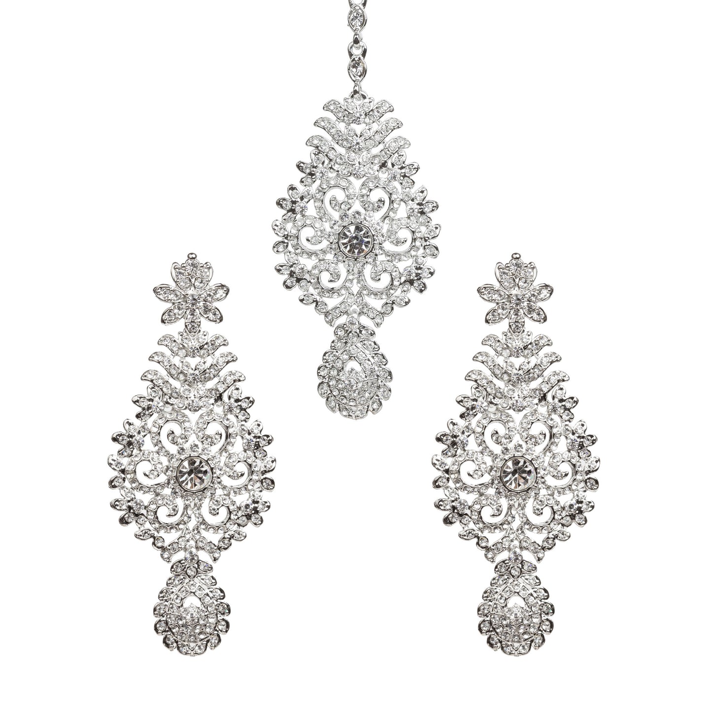 Bindhani silver-toned earrings and maang tikka set embellished with clear stones and sparkling crystal accents. The earrings feature a floral top, intricate leaf and scrollwork design with a central round stone, and a detailed teardrop-shaped stone-studded bottom drop. The matching maang tikka showcases a coordinating ornate floral design with a central round stone and a teardrop-shaped stone-studded drop. Front view displayed on a white background.