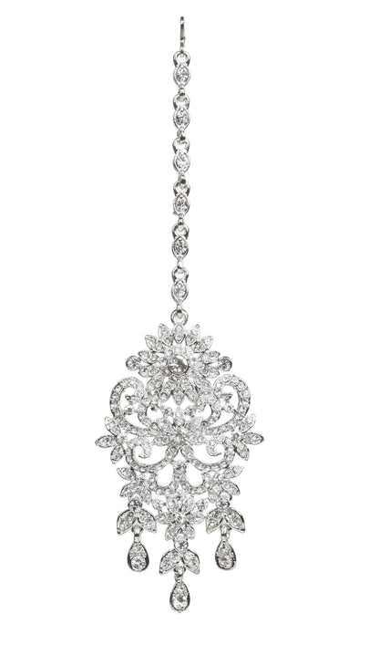 Bindhani silver-toned maang tikka featuring clear stones with sparkling crystal accents. The tikka showcases an intricate floral and leaf-inspired design with detailed openwork scrollwork, a central floral motif, and three dangling teardrop-shaped clear stone drops. Front view displayed on a white background.