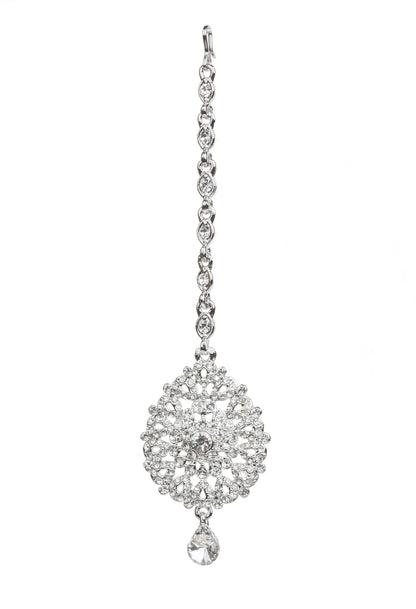 Bindhani silver-toned maang tikka embellished with clear stones and intricate floral detailing. The tikka features a delicate stone-studded chain, a round floral centerpiece with sparkling crystal accents, and one dangling clear teardrop-shaped stone charm. Front view displayed on a white background.